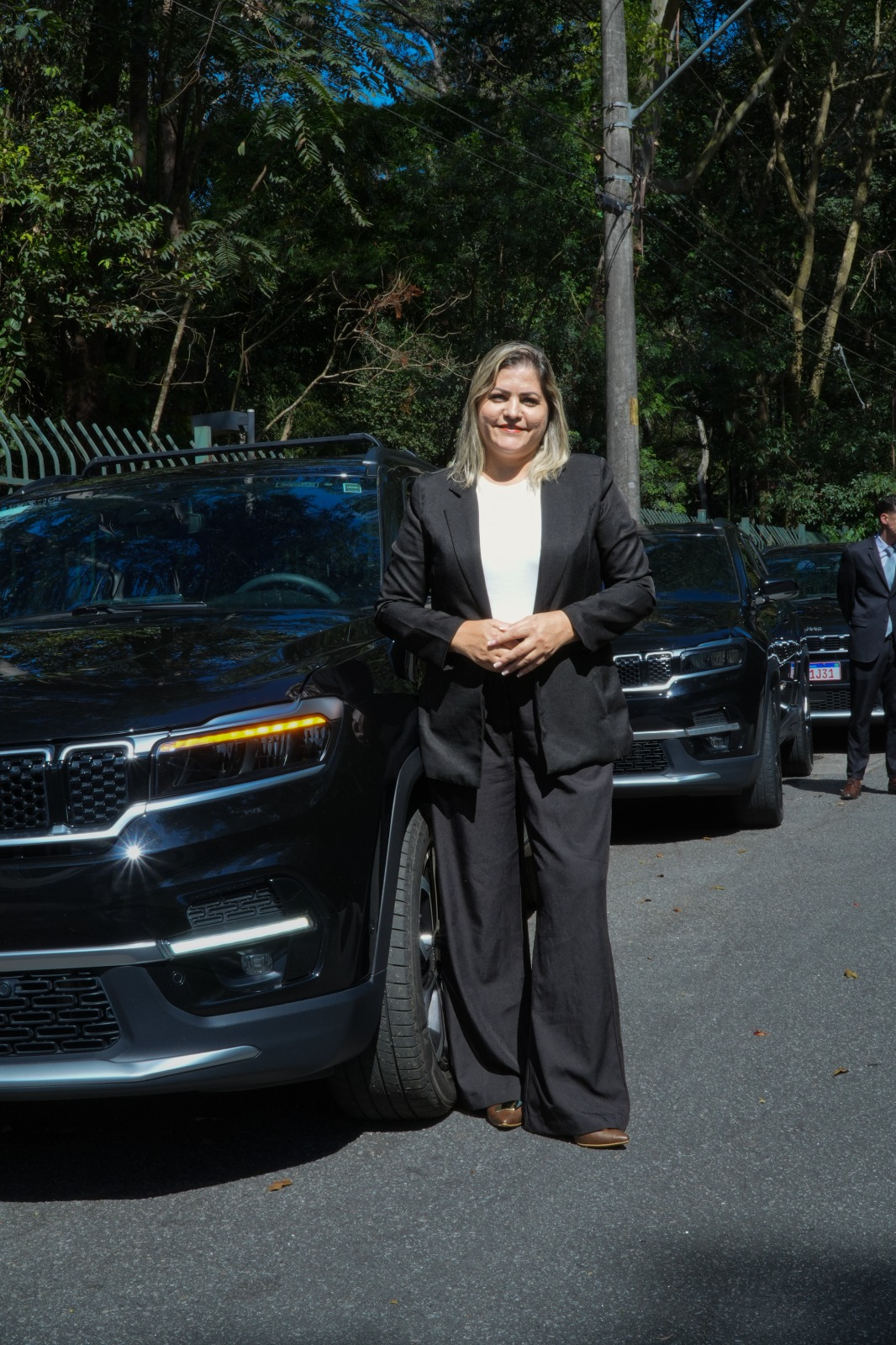 Transfersafe executive chauffeur next to vehicle, impeccable posture